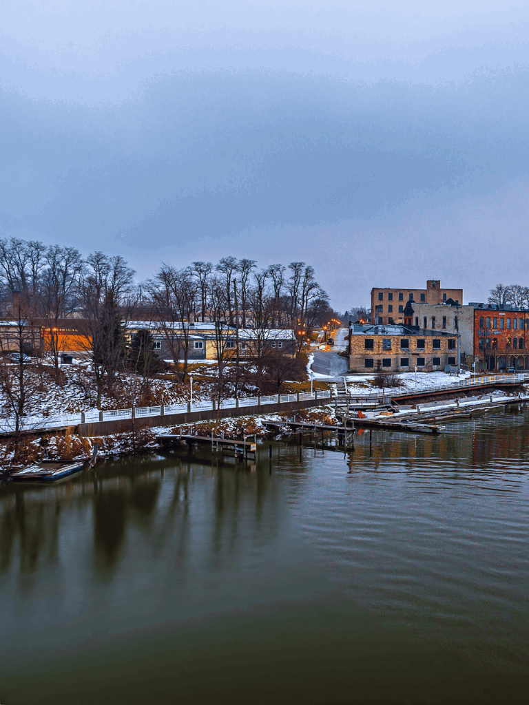 Scenic riverside town with historic buildings and snow-covered landscape in winter.