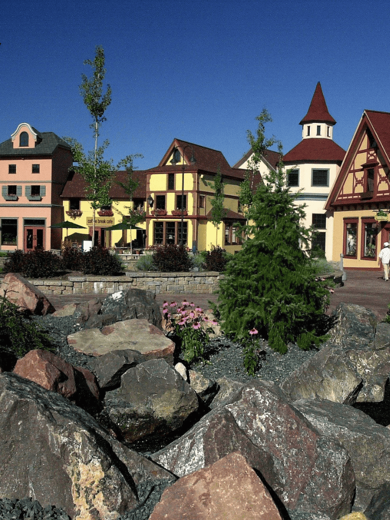 Charming European-style village with colorful buildings and scenic landscaping.