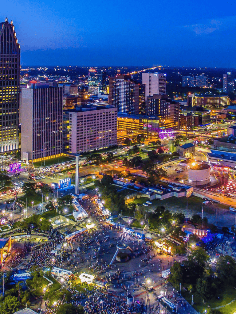 Aerial view of a vibrant city skyline at dusk with busy streets and illuminated skyscrapers for urban navigation and city exploration.