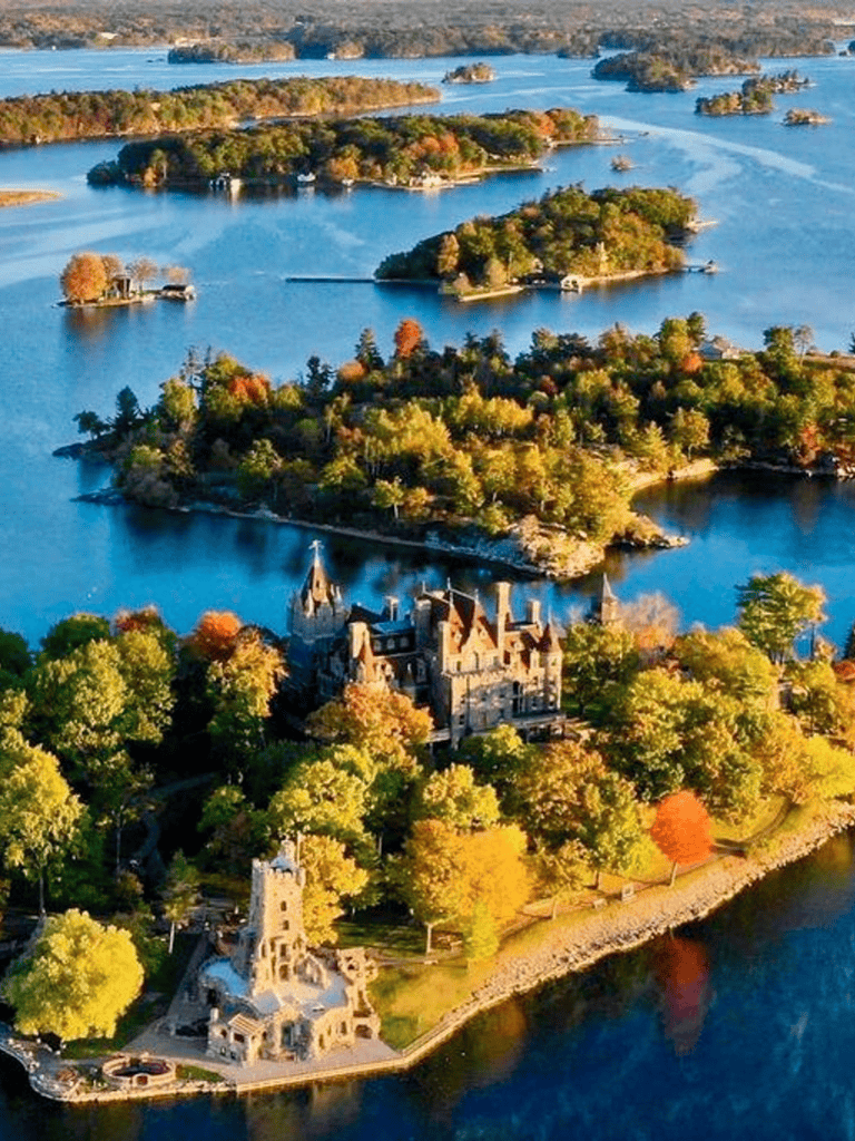 Colorful autumn landscape of Lake Lancelot with a castle surrounded by trees and water, scenic view of scenic islands and waterways.