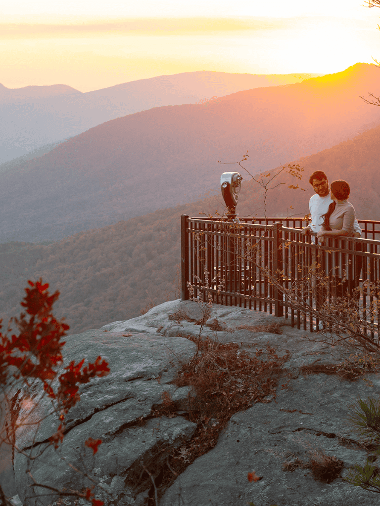Overlooks mountain sunset view at scenic lookout with people enjoying the sunset scenery.