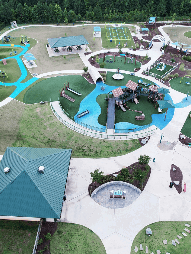 Bright outdoor play area with swings, slides, and walking paths at QuestForDirections park.