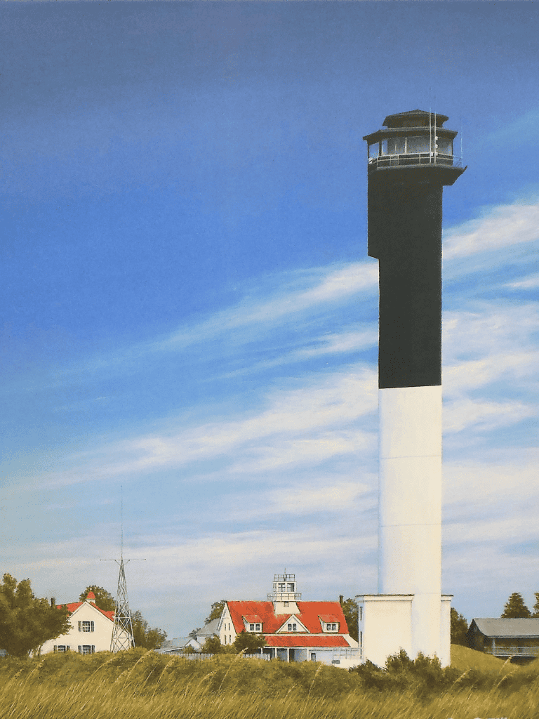 Seaside lighthouse with clear blue sky, coastal houses, and grassy landscape, guiding travelers along scenic routes.