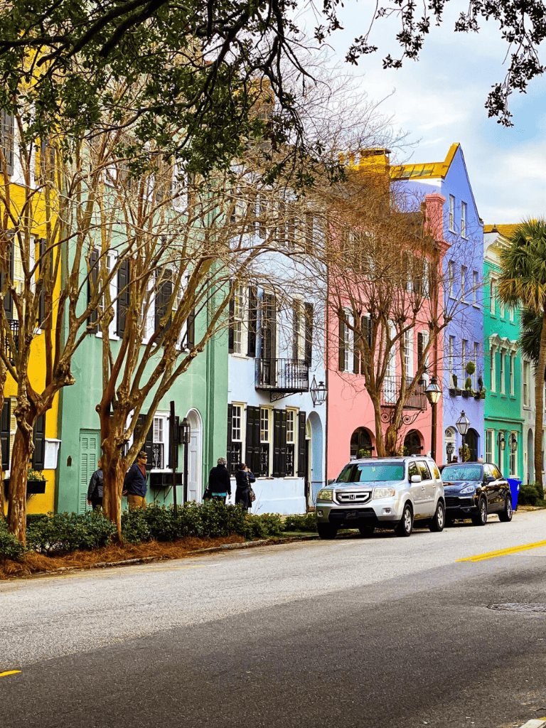Colorful row of historic houses on a lively street in Charleston, South Carolina.