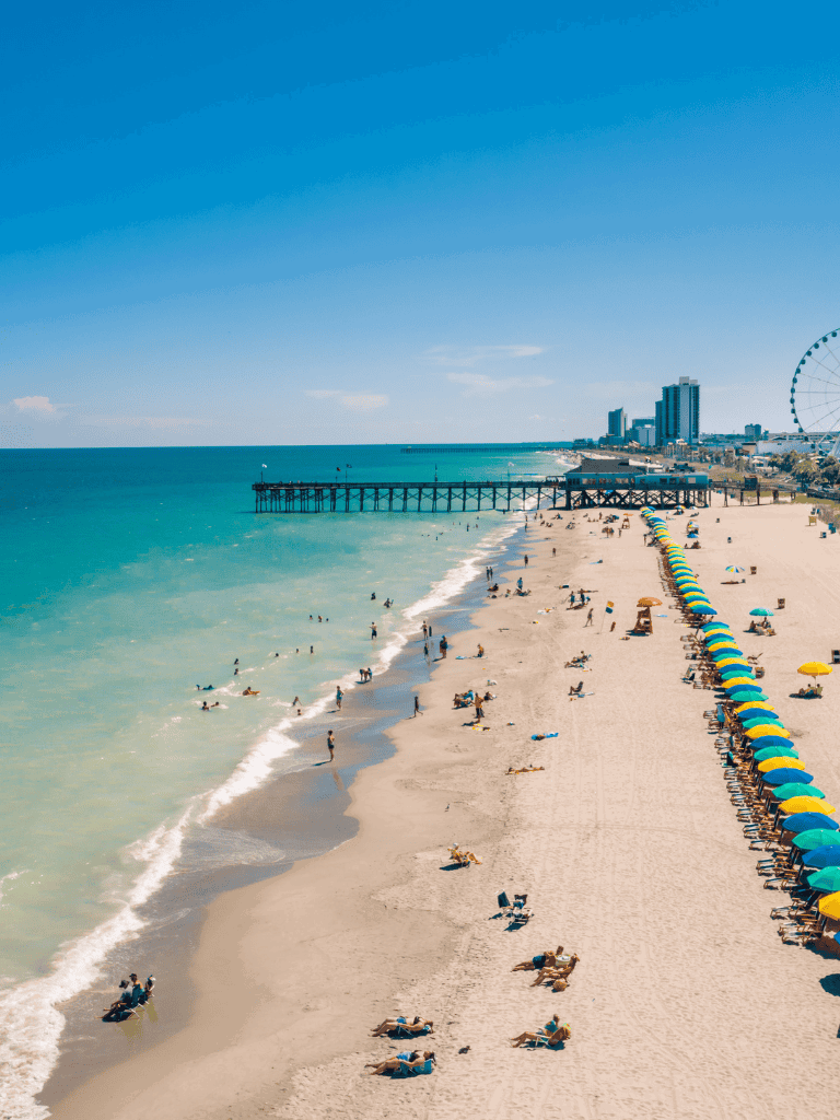 Stunning beachfront scene with clear blue water and colorful umbrellas, perfect for travel and vacation planning.