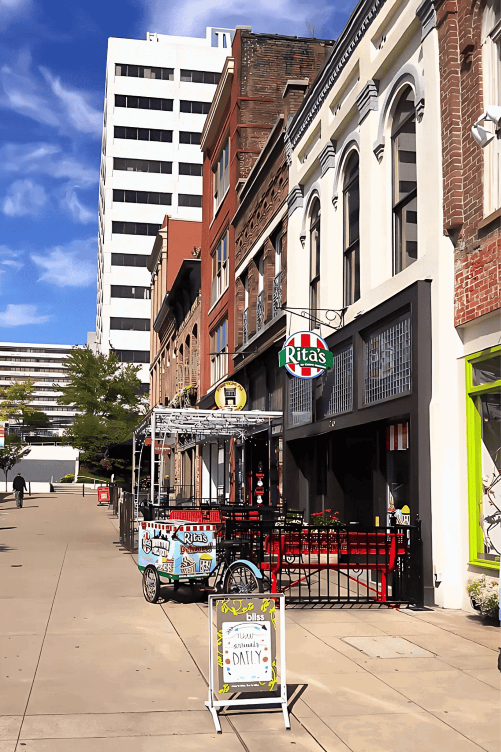 1. Bright city street with restaurants, outdoor seating, and modern buildings smog clouds in the background.
