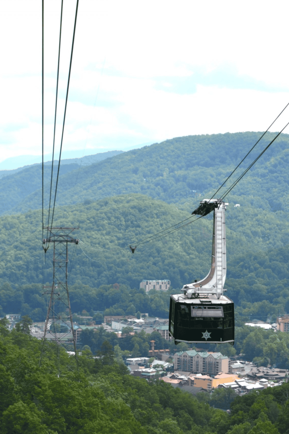Cable car ride over green mountainous landscape for scenic city views.