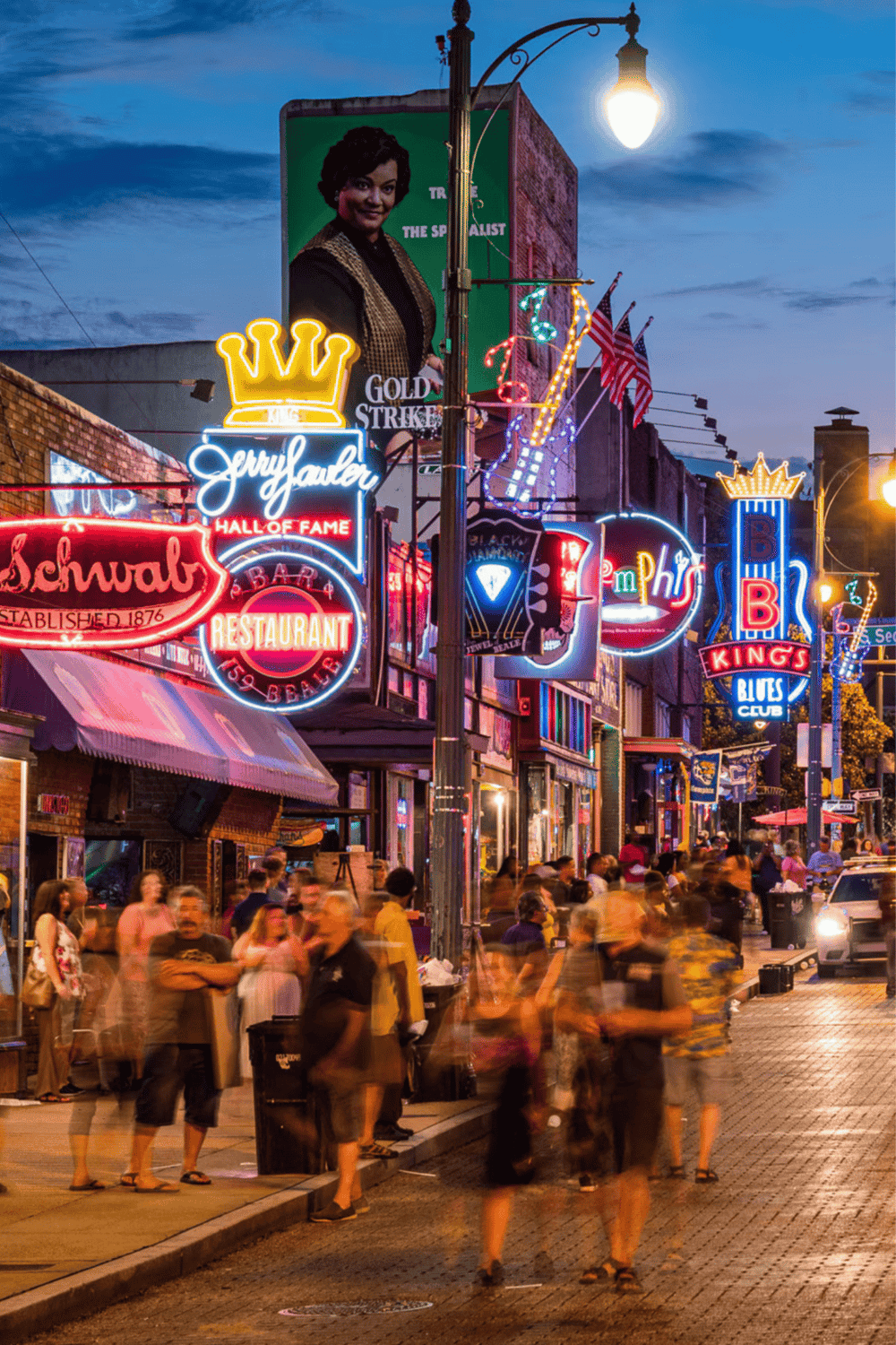 Bright neon nightlife on Beale Street with bars, live music, and vibrant crowd in Memphis, Tennessee.