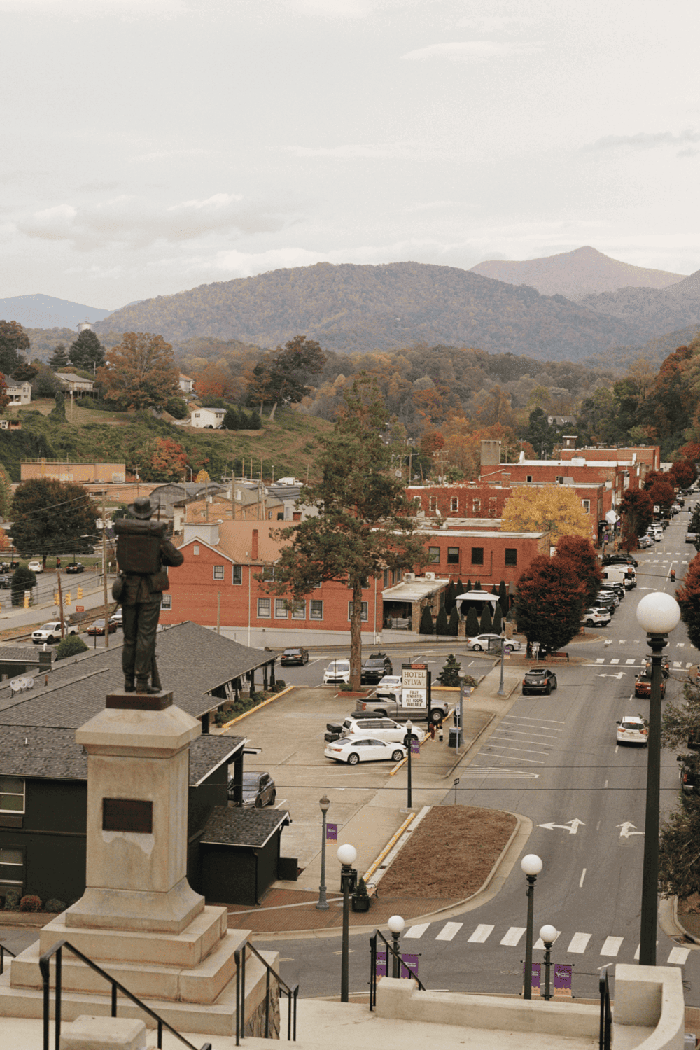 Historic downtown town with mountain backdrop, featuring streets, buildings, and fall foliage.