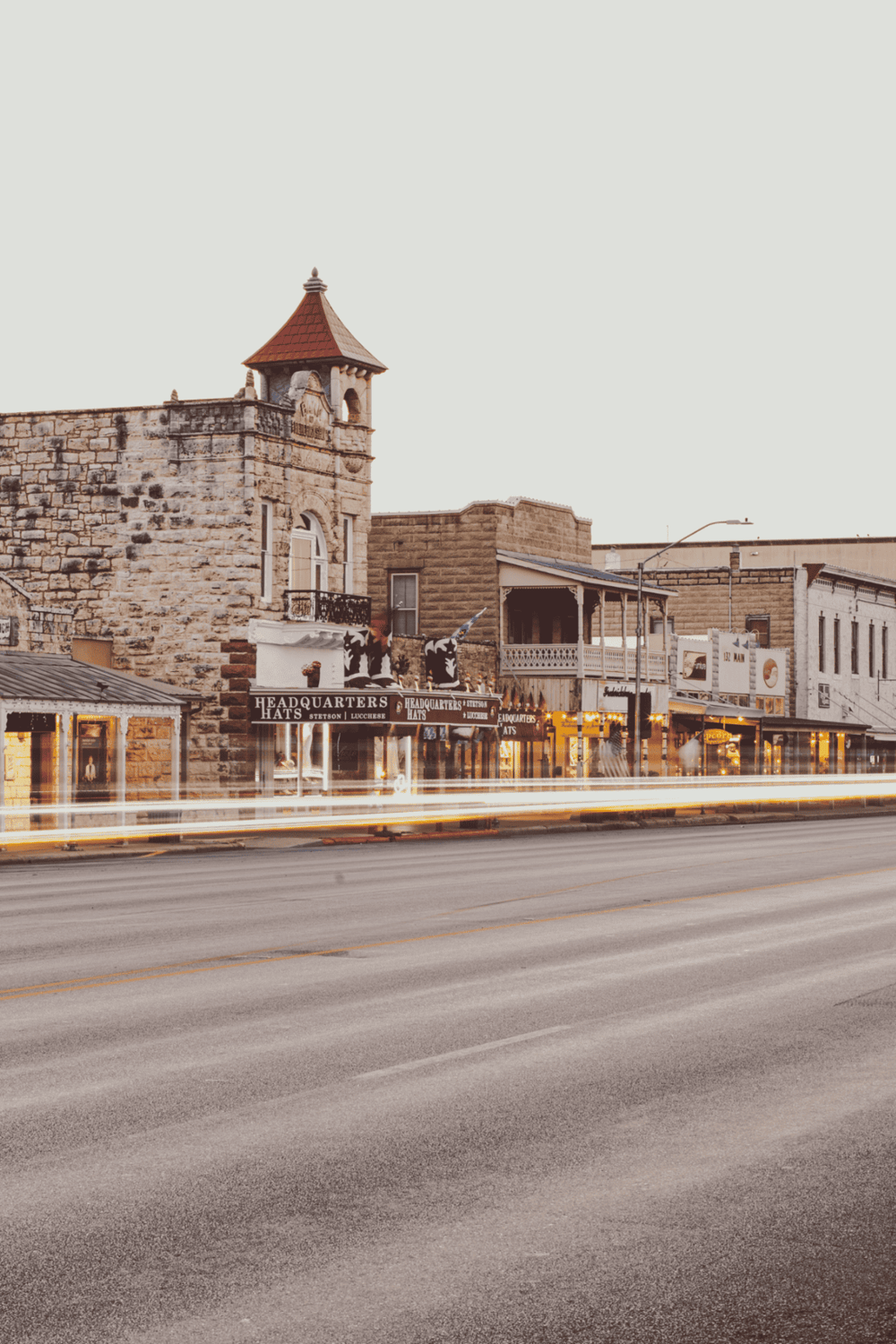 Charming historic downtown street with shops and restaurants, iconic architecture, and warm evening lights.