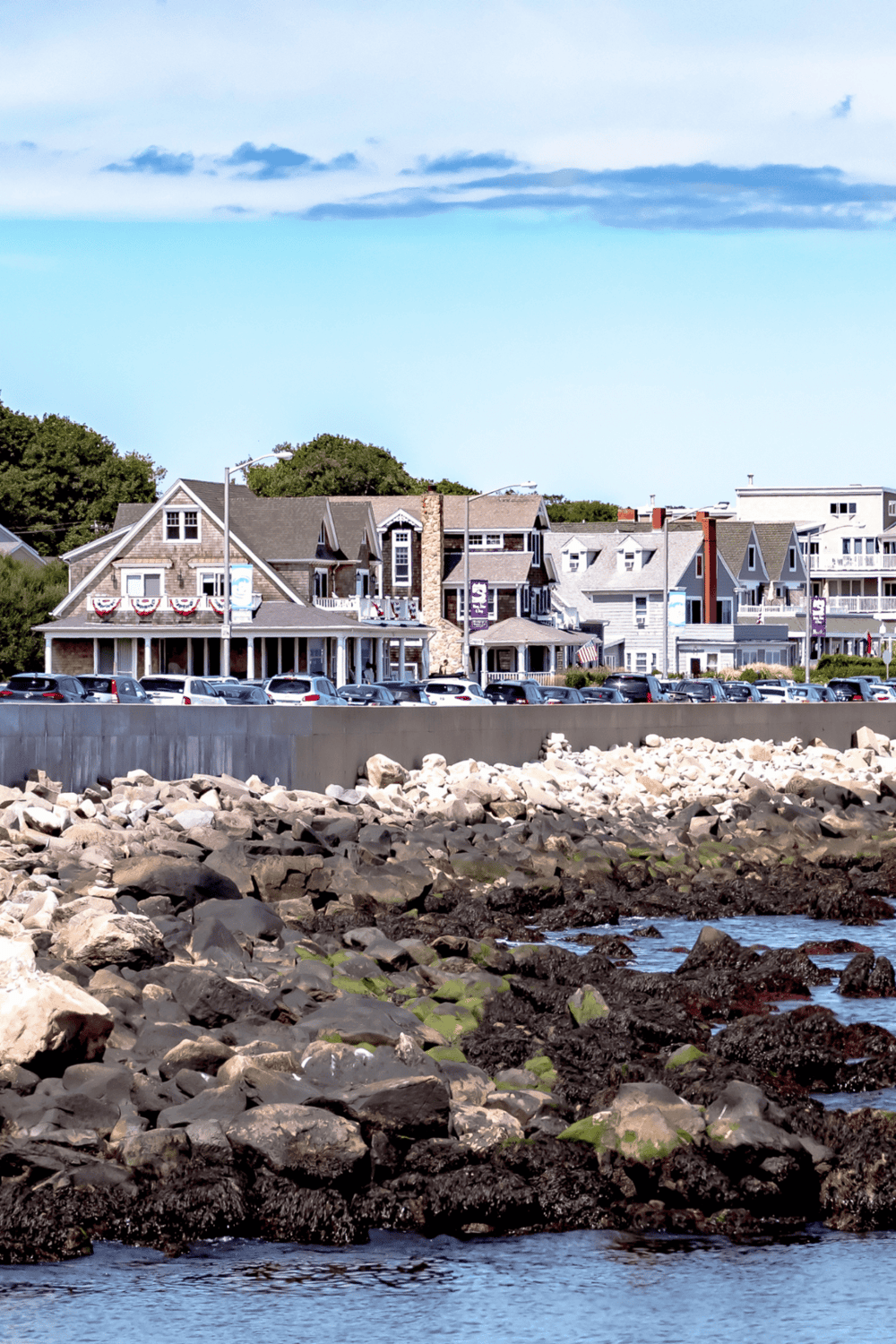 Coastal town with historic houses, waterfront, and parking, ideal for seaside travel and exploration.