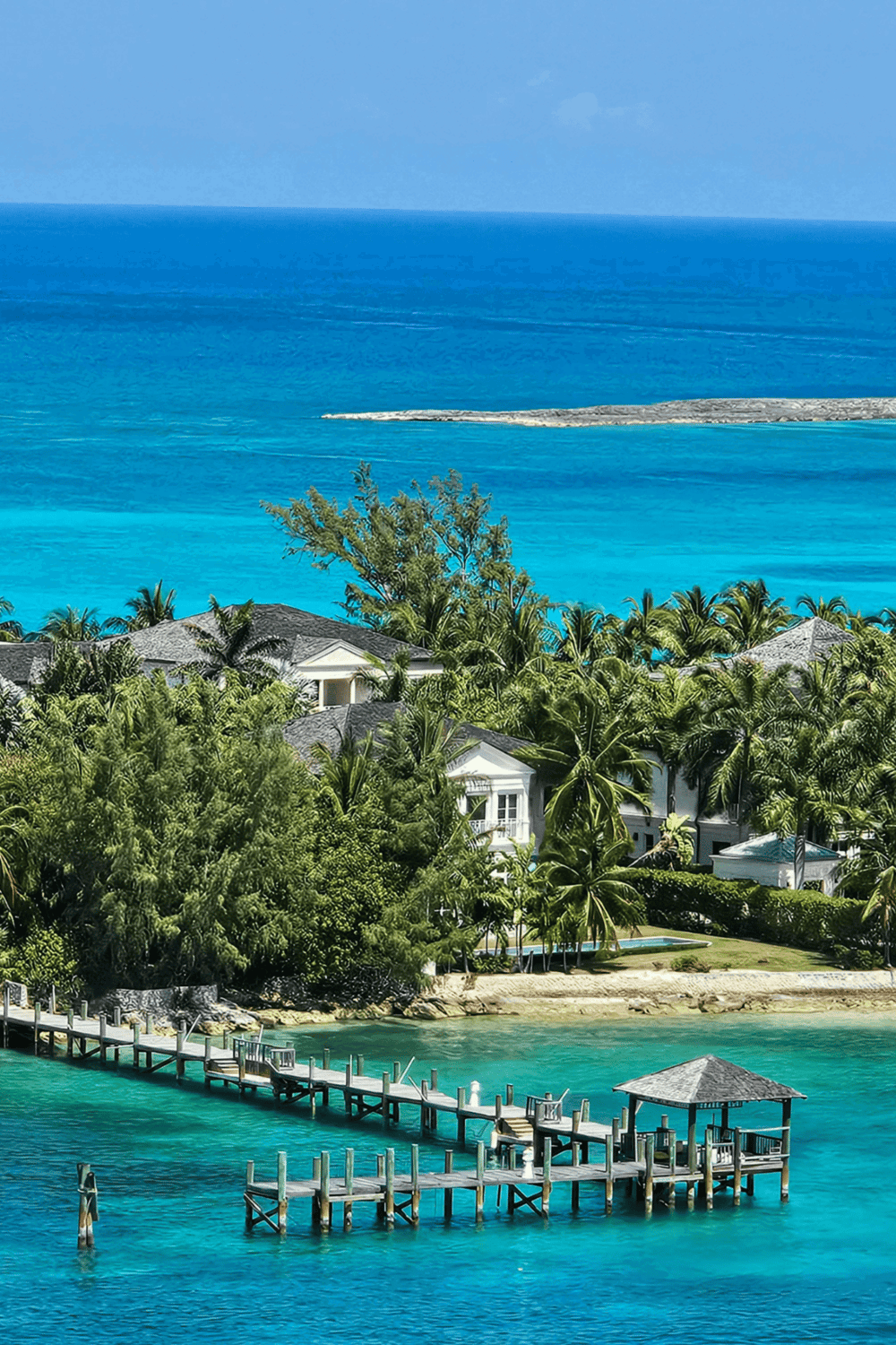 Overwater bungalow with tropical beach view, palm trees, and clear blue ocean scenic landscape.