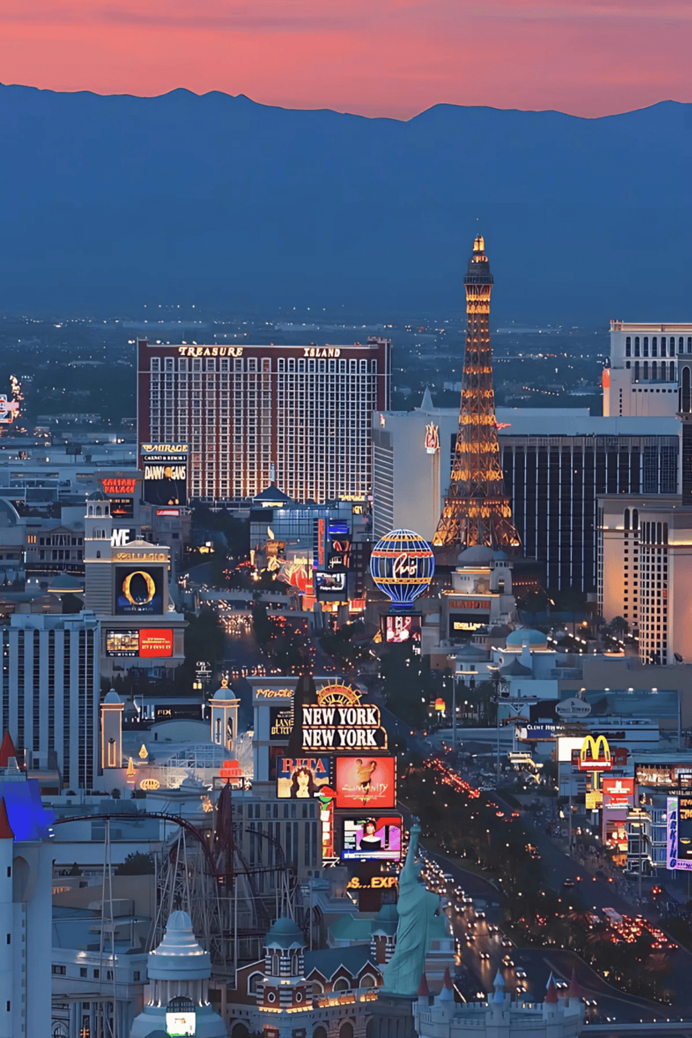 Las Vegas Strip skyline at dusk with iconic landmarks and vibrant city lights.