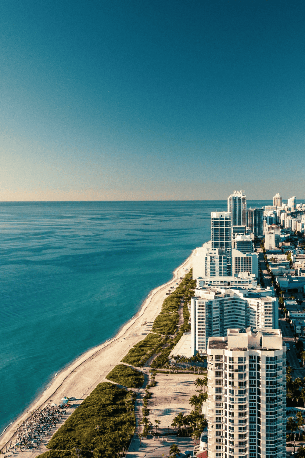 Aerial view of Miami Beach skyline with ocean and sandy beach shoreline.