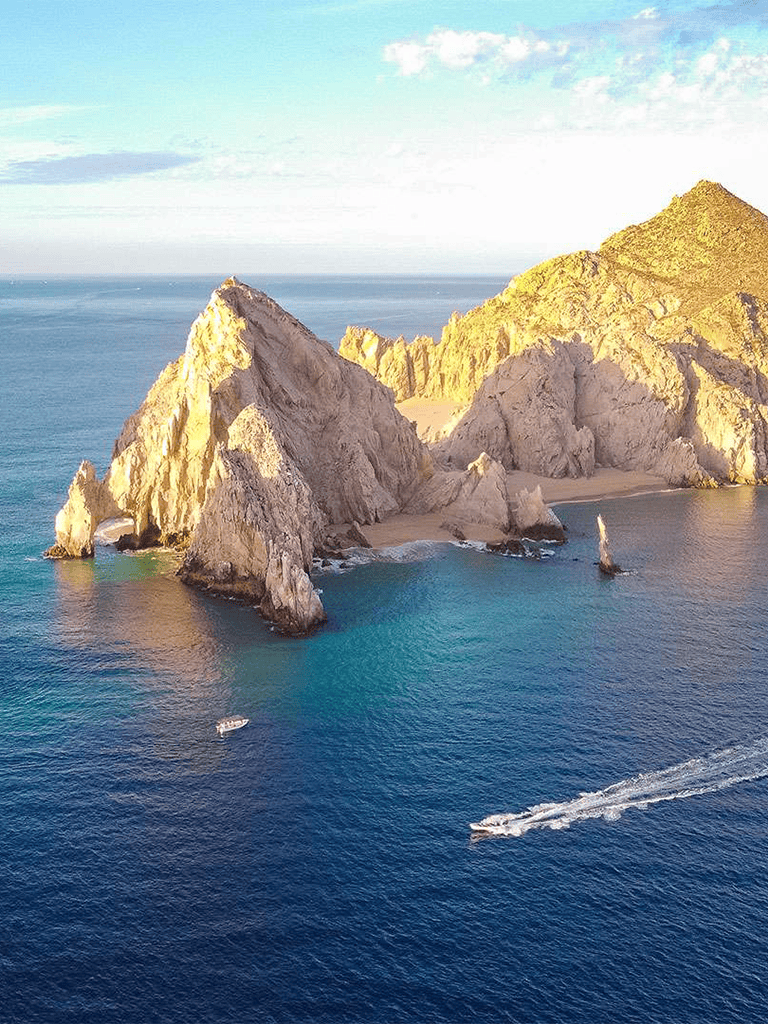 Majestic sea stacks and coastal cliffs at Laguna de la Cueva in Mexico, scenic ocean views and boat activity.