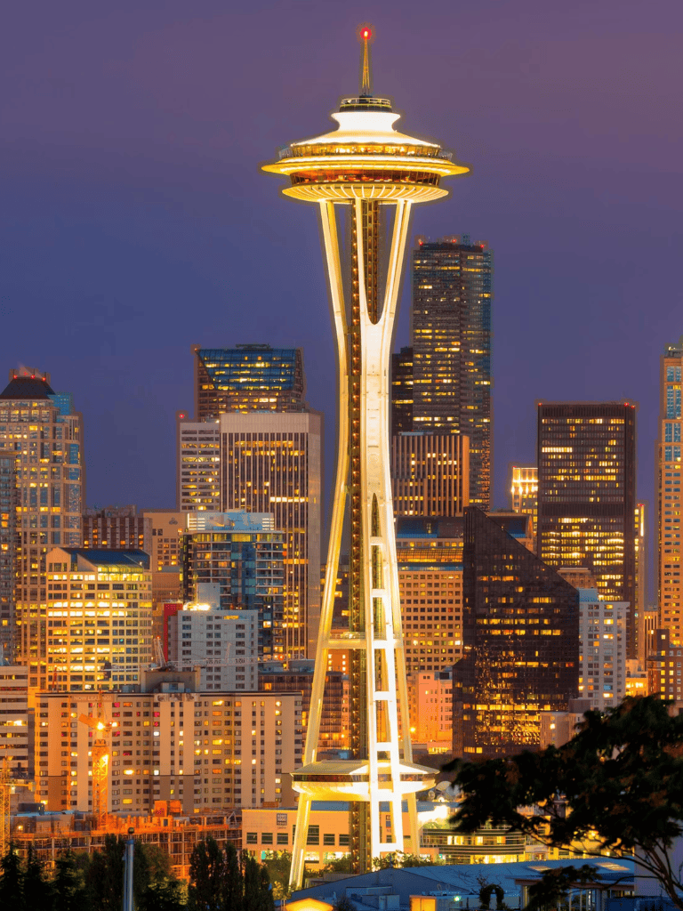 Bright illuminated Seattle Space Needle at night, vibrant city skyline, popular travel destination.