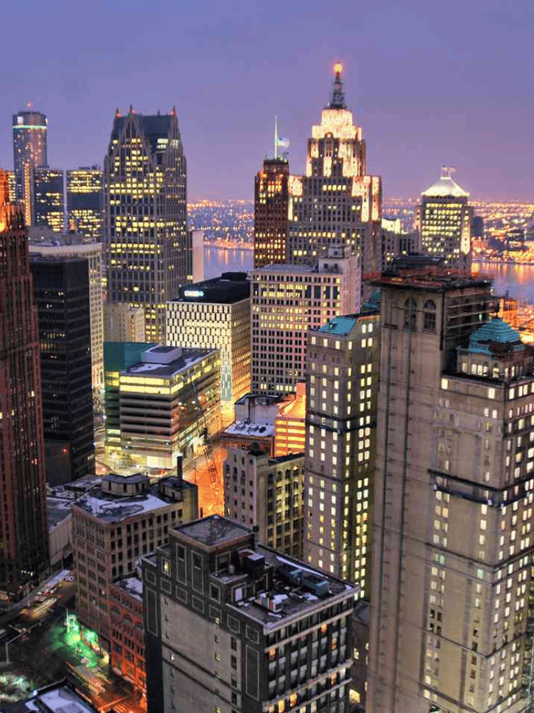 Vibrant downtown skyscrapers illuminated at dusk, showcasing city skyline and urban lights scene.