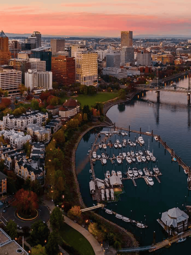 Aerial view of Portland Oregon skyline at sunset with marina and boats in the foreground.