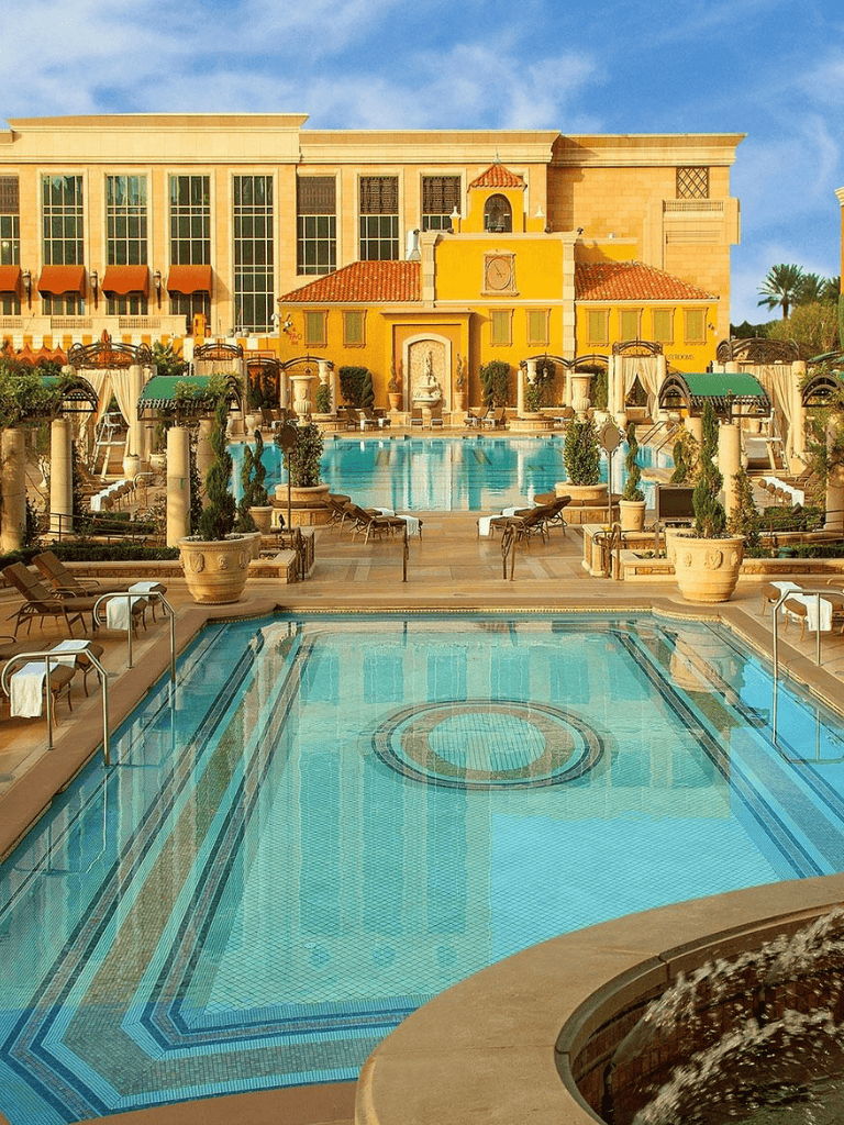 Luxurious hotel pool area with elegant architecture and lush surroundings.
