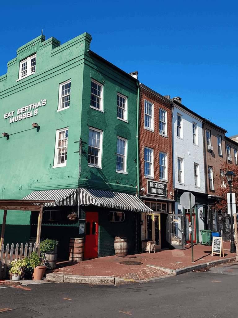 Colorful brick buildings on a city street with shops and outdoor decor, showcasing vibrant architecture and local retail spots.