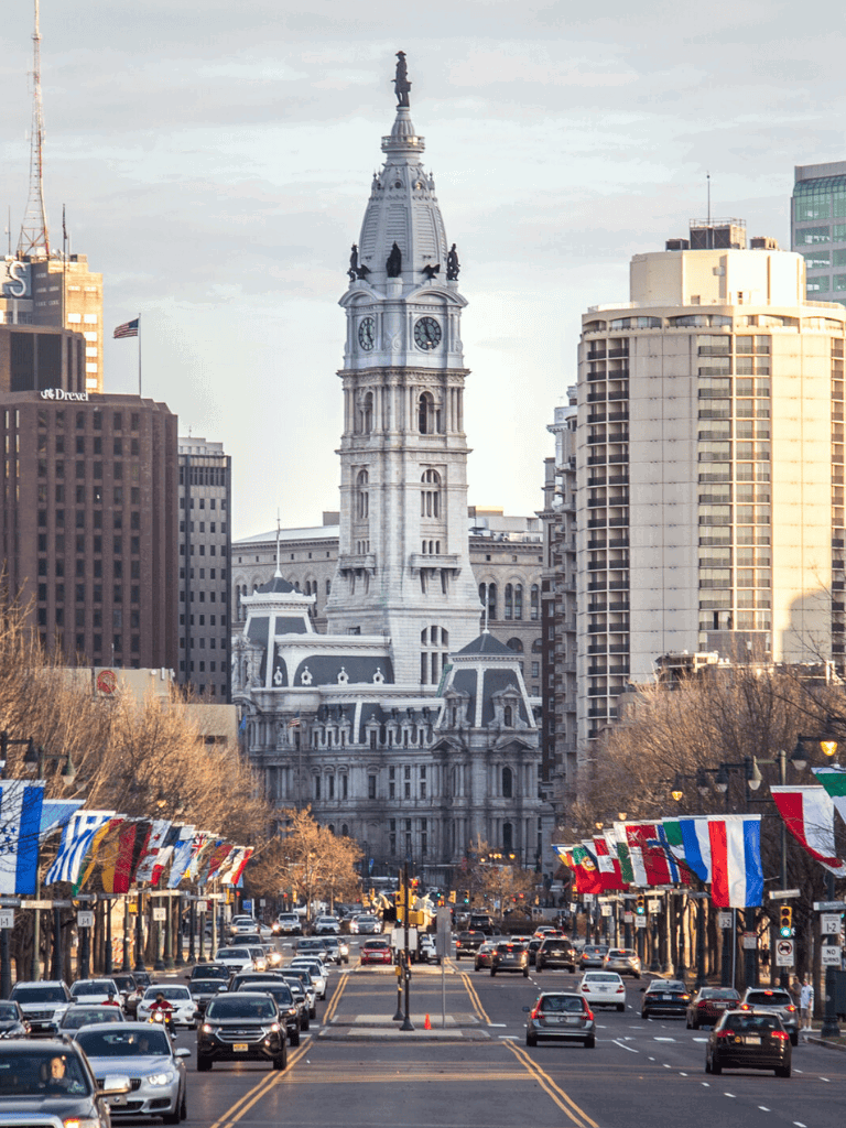 1. Historic Philadelphia City Hall with flags and busy street scene.
