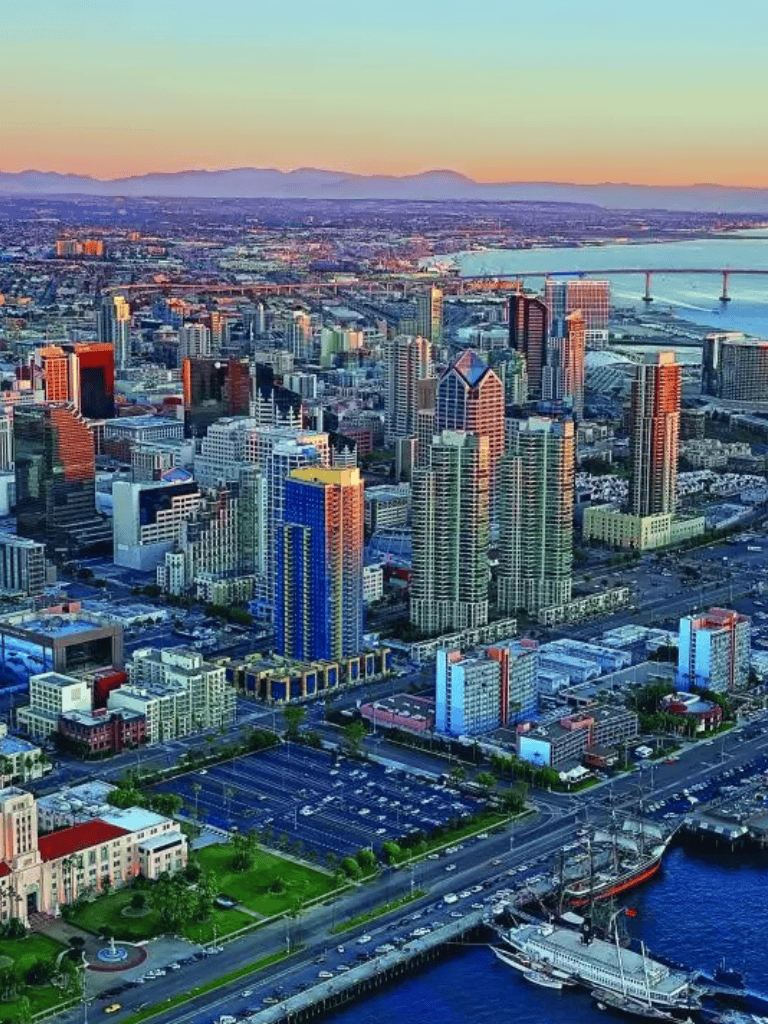 Vibrant downtown San Francisco skyline at sunset, showcasing skyscrapers and bridges.