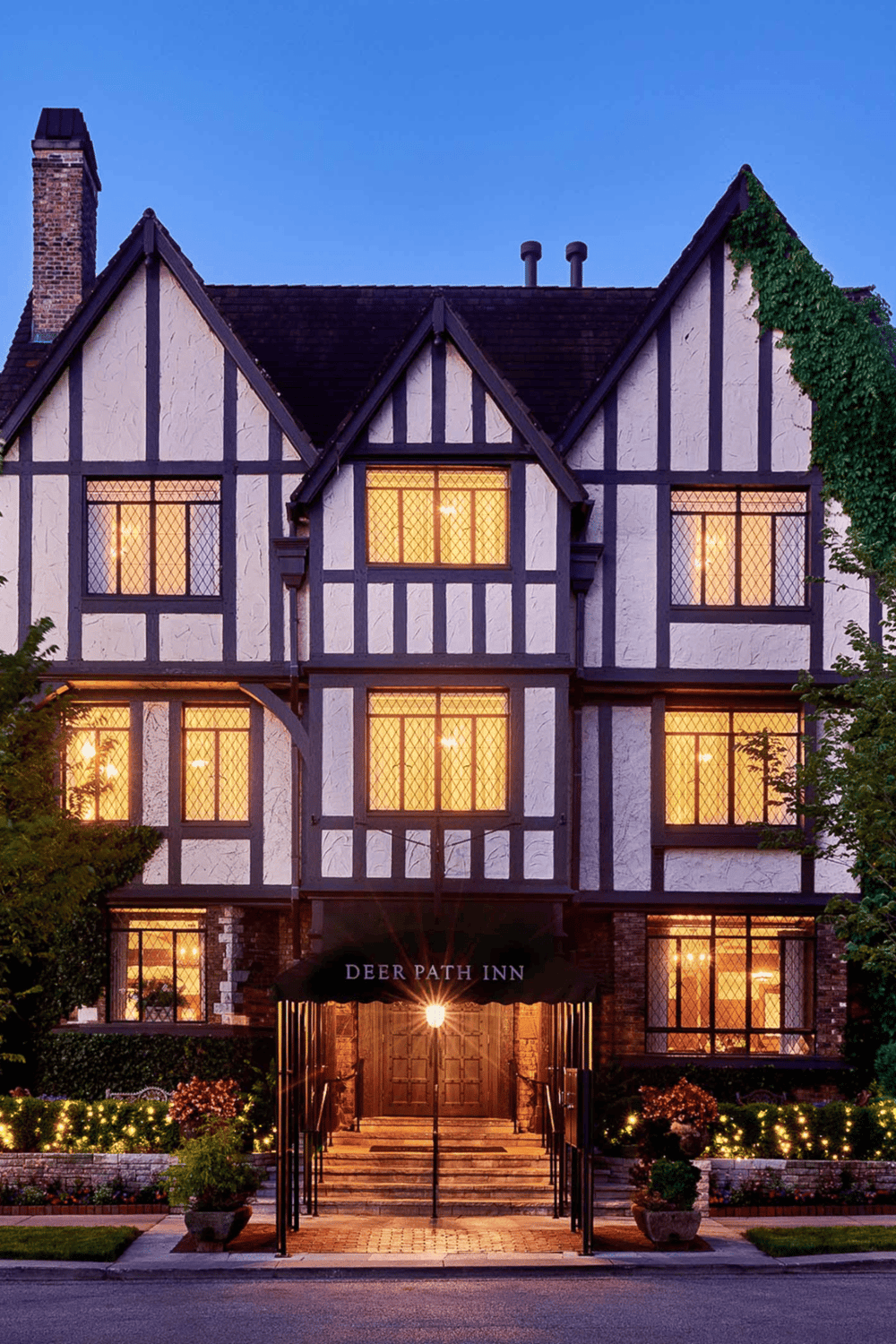 Charming Tudor-style inn with illuminated windows, inviting ambiance, perfect for travel fatigue recovery.