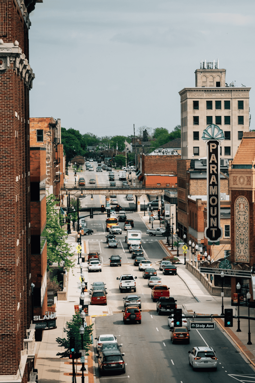 Downtown city street with parking, traffic, and prominent historic buildings.