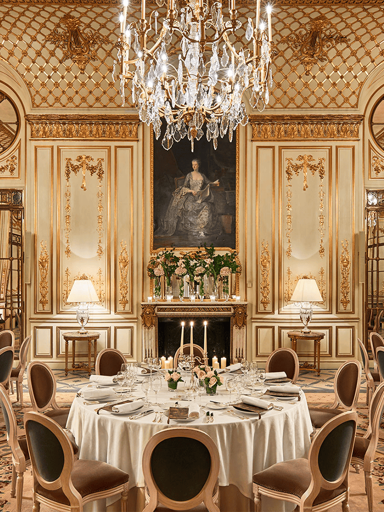Elegant luxury dining room with crystal chandelier and ornate gold accents.