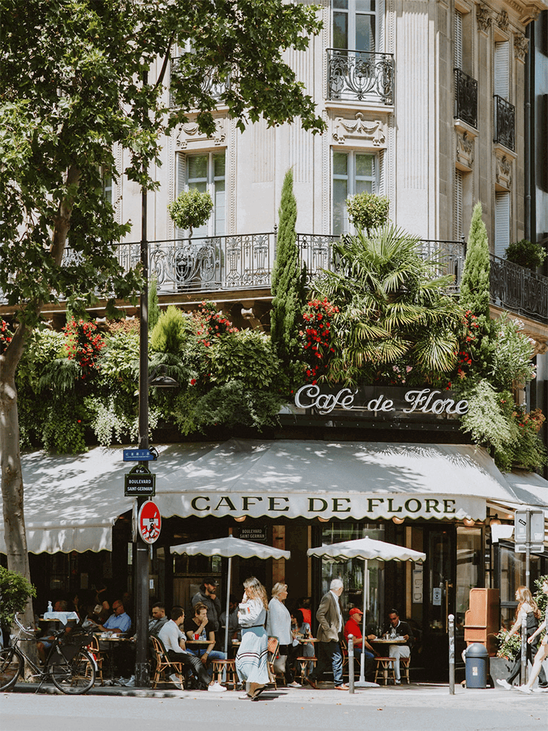 Paris café terrace with greenery and outdoor seating, authentic French experience.