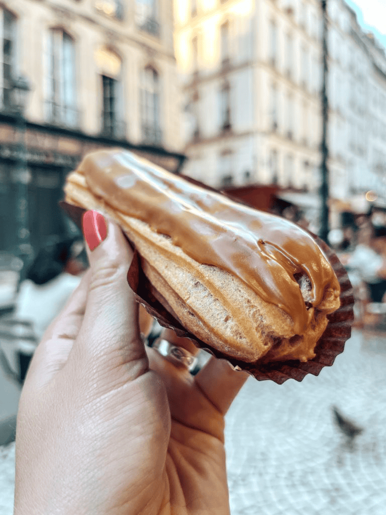 Warm caramel-filled éclair on a city street, perfect for coffee breaks and sweet cravings.