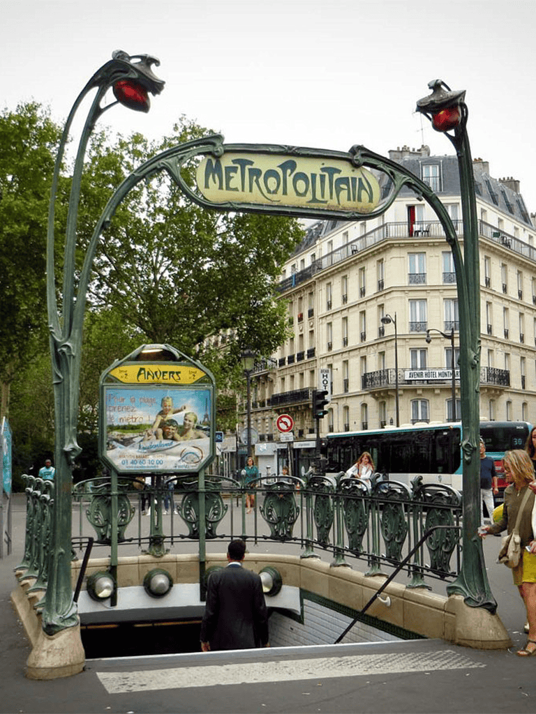 Historic Paris Metro entrance with Art Nouveau design, central Paris subway, ornate ironwork, and travelers.