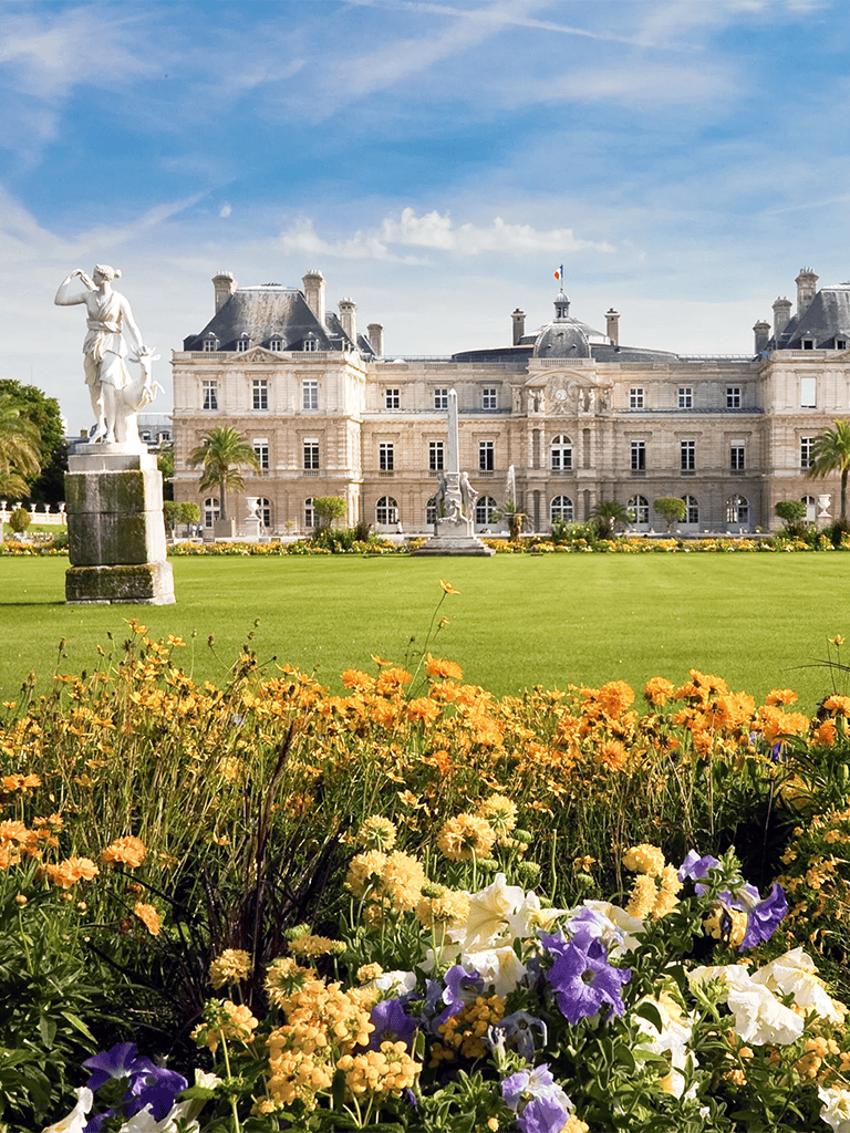 Elegant French-style chateau with lush gardens and sculptures, perfect for luxury travel and historical exploration.