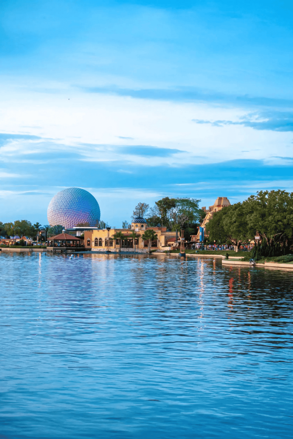 Disney World EPCOT ball and park skyline at sunset in Orlando, Florida, featuring popular visitor attractions and scenic waterfront views.