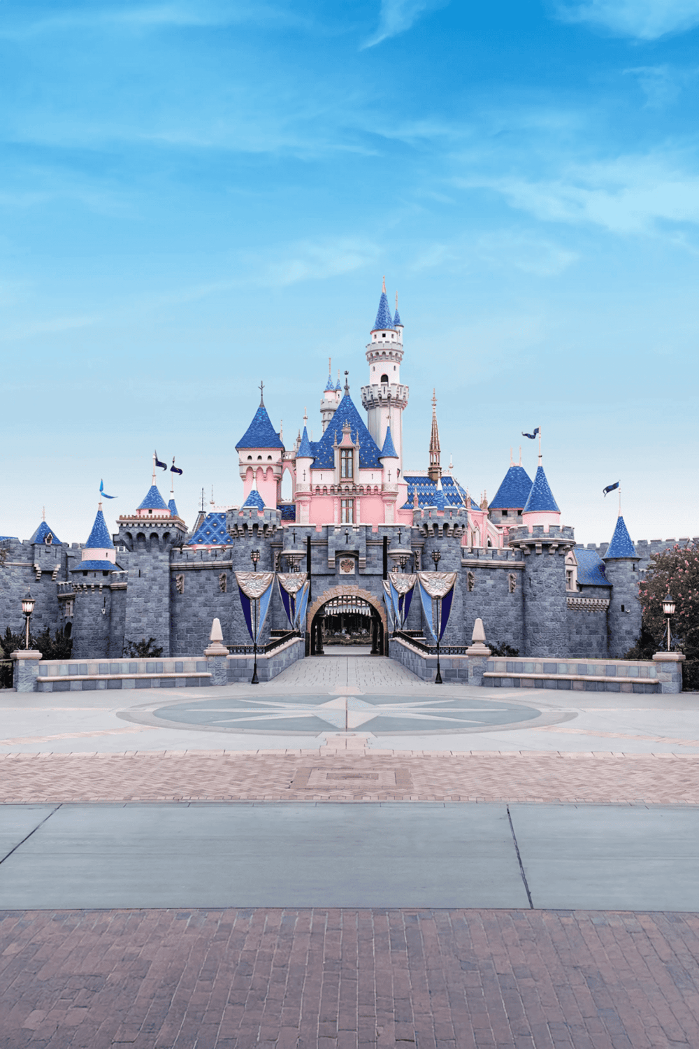 Colorful Disney castle with pink and blue turrets at Disneyland, California, iconic fairy tale destination.
