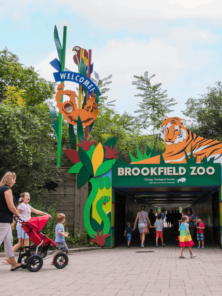 Colorful zoo entrance with animals and visitors at Brookfield Zoo, Chicago.
