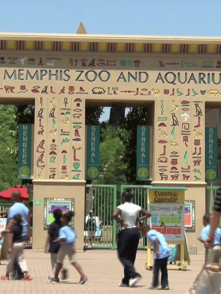 Memphis Zoo and Aquarium entrance with visitors and hieroglyphic decorations.