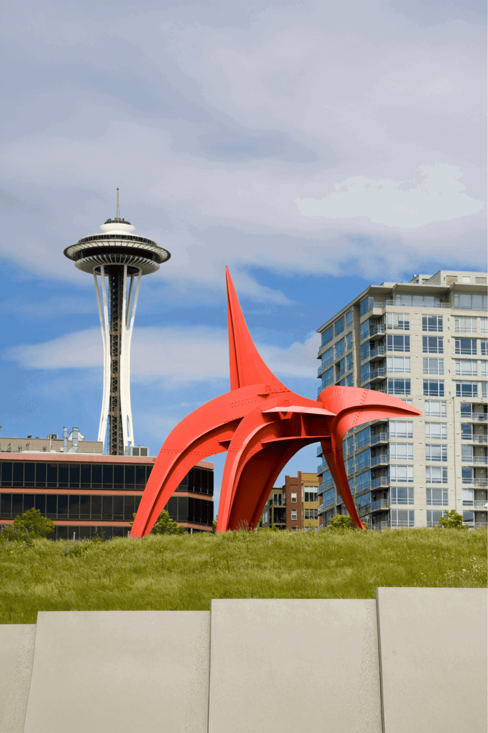 Colorful public art sculpture of a red starfish with the Seattle Space Needle in the background.