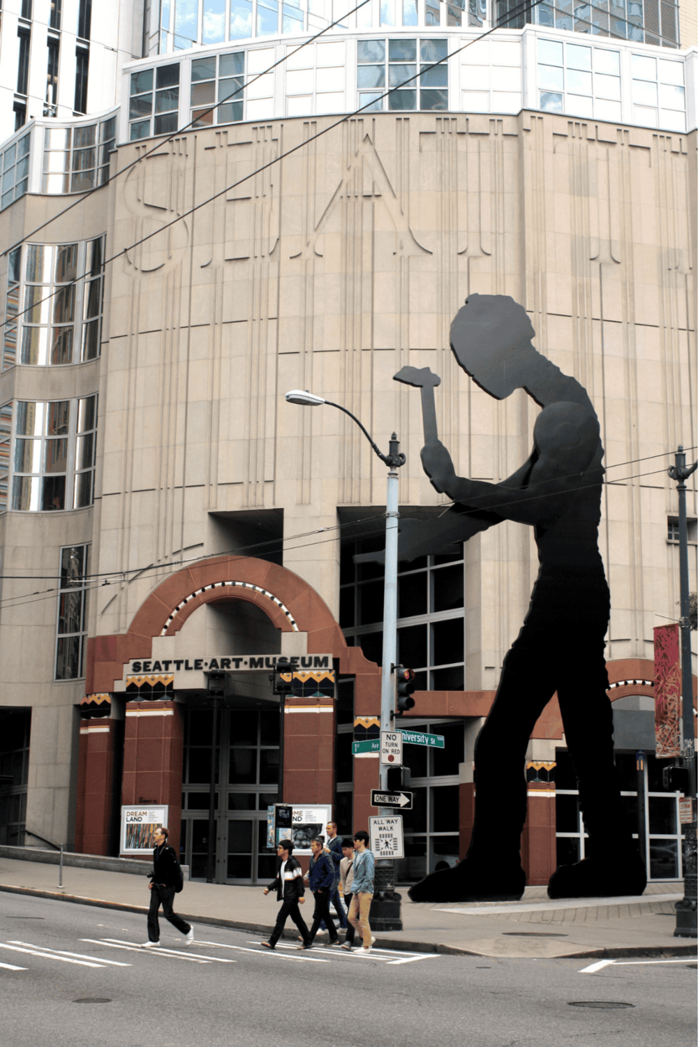 Silhouette of a person reading outside Seattle Art Museum, modern urban scene, street view, downtown Seattle, public art display.