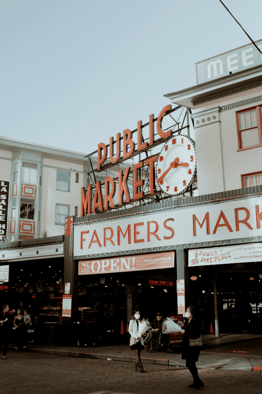 Historic San Francisco Ferry Building with farmers market, busy urban scene, and iconic clock.