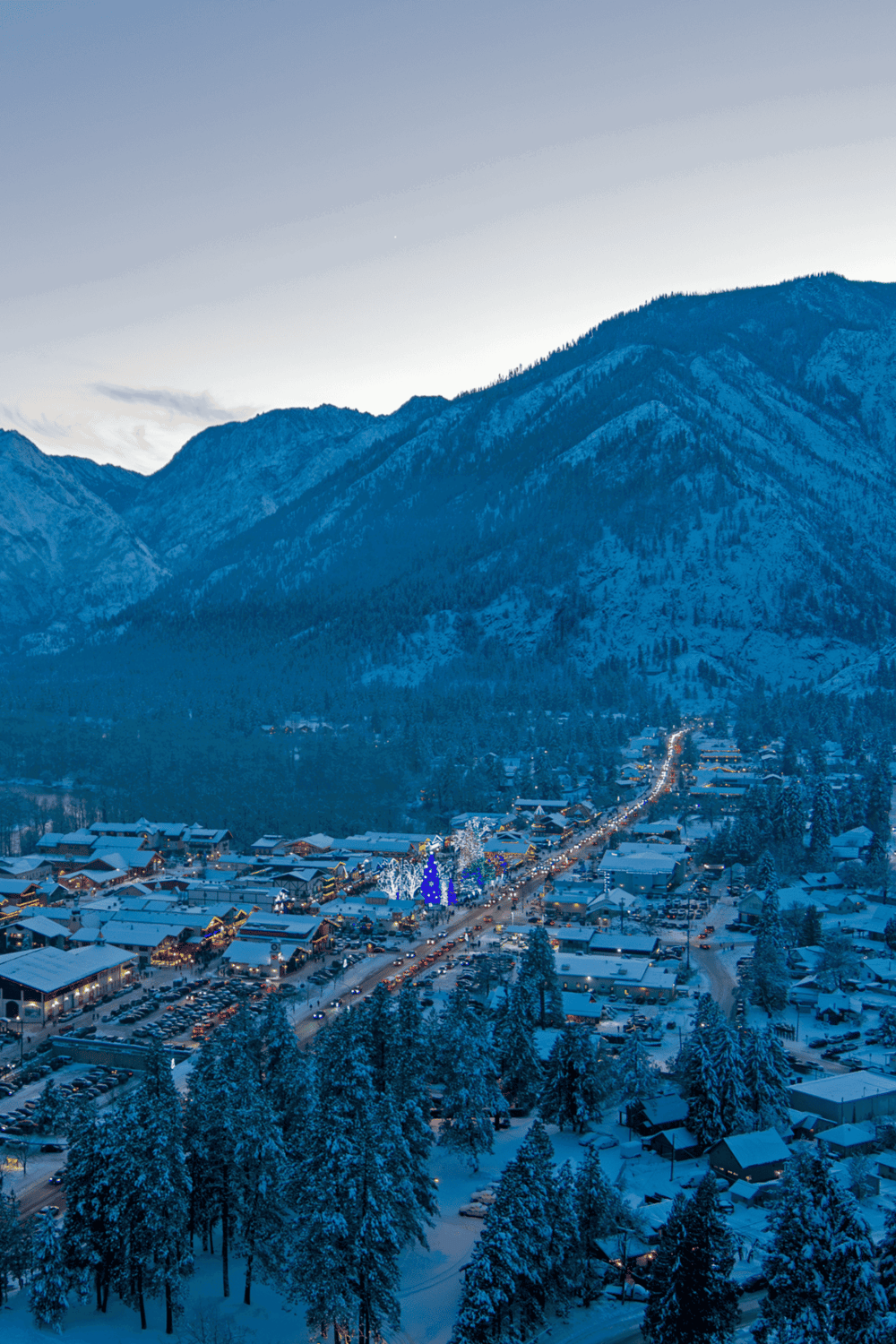 Snow-covered mountain town with festive holiday lights and scenic winter landscape near QuestForDirections.