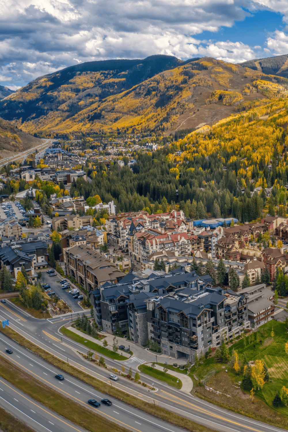 Bright mountain town with colorful autumn foliage and modern residential buildings.
