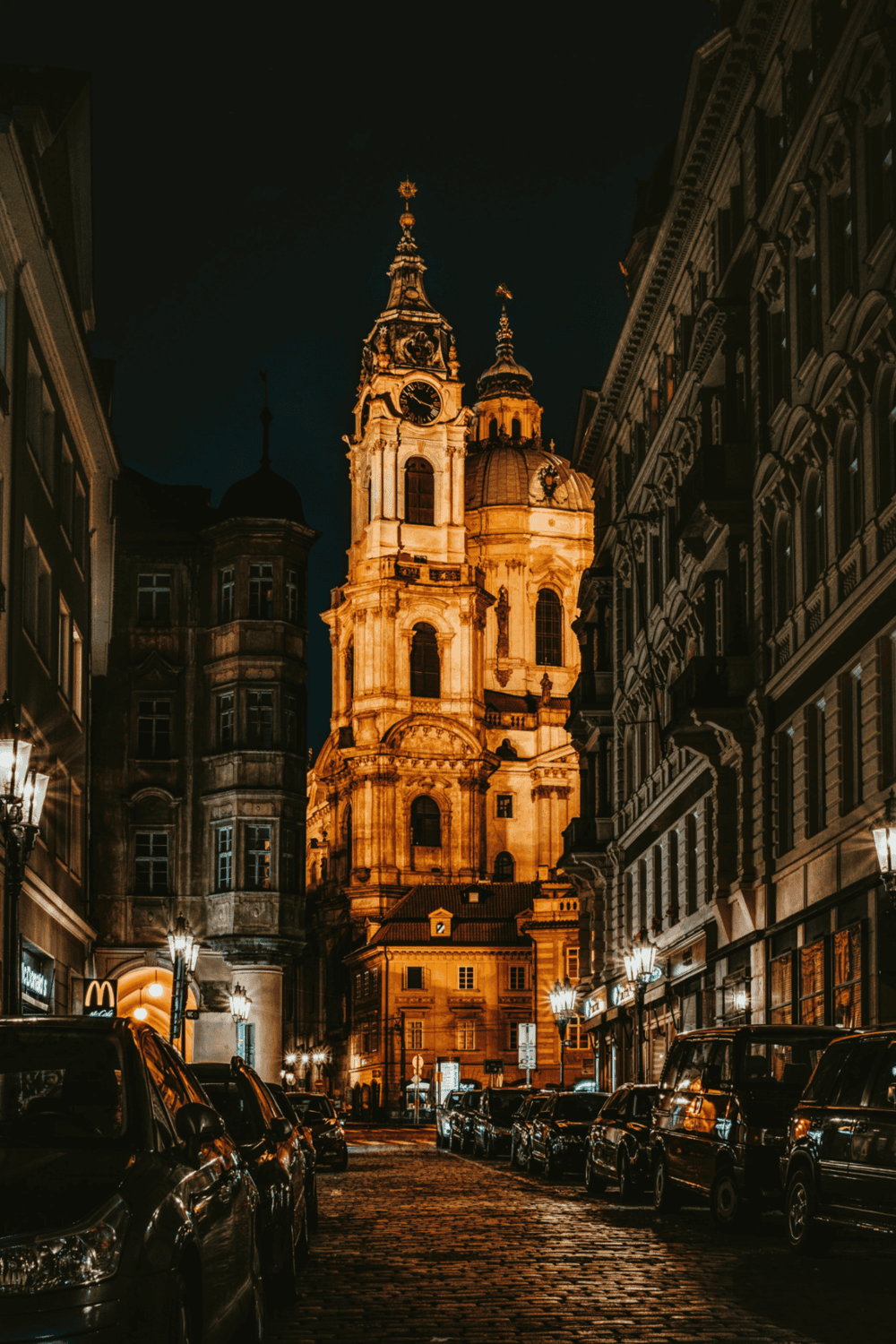Ancient church illuminated at night in a historic European city street.