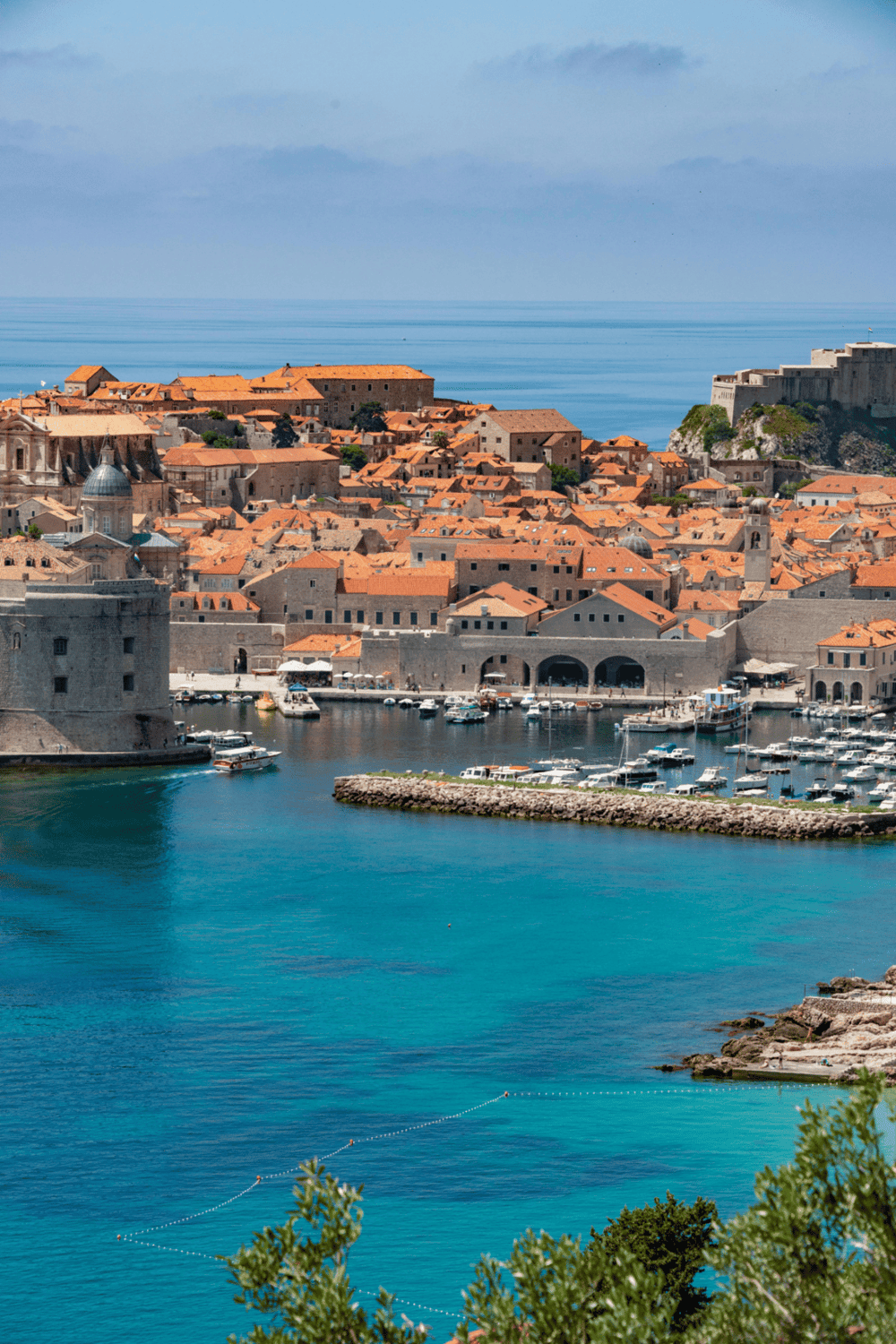 Historic Dubrovnik old town with red rooftops and marina, Croatia travel destination.