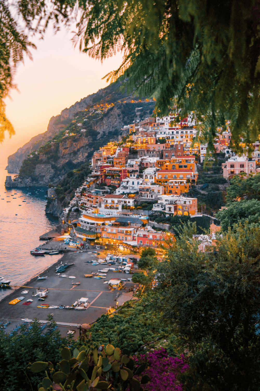 Colorful cliffside village in Positano with sunset lighting and scenic coastal views, Italy travel destination, Mediterranean seaside town, picturesque harbor.