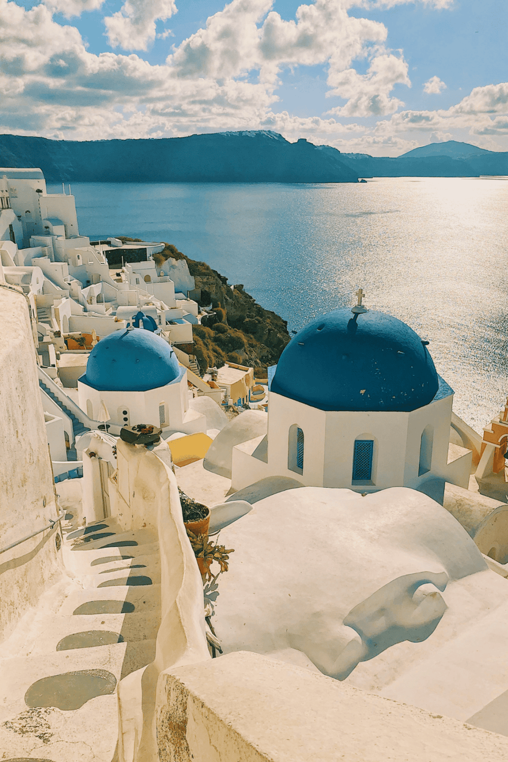 Breathtaking view of Santorini's white buildings and blue domes overlooking the sea.
