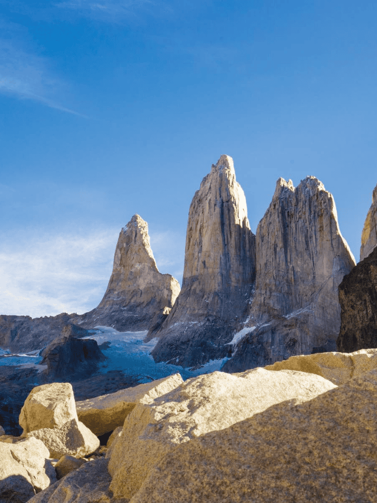 Majestic mountain peaks with rocky foreground and bright blue sky, perfect for outdoor adventure and nature exploration.