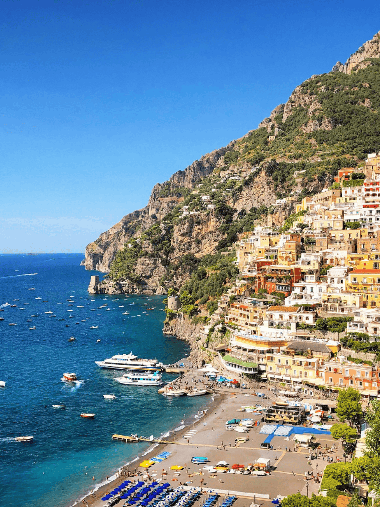 Vibrant Amalfi Coast coastal village with colorful hillside homes and blue Mediterranean Sea.