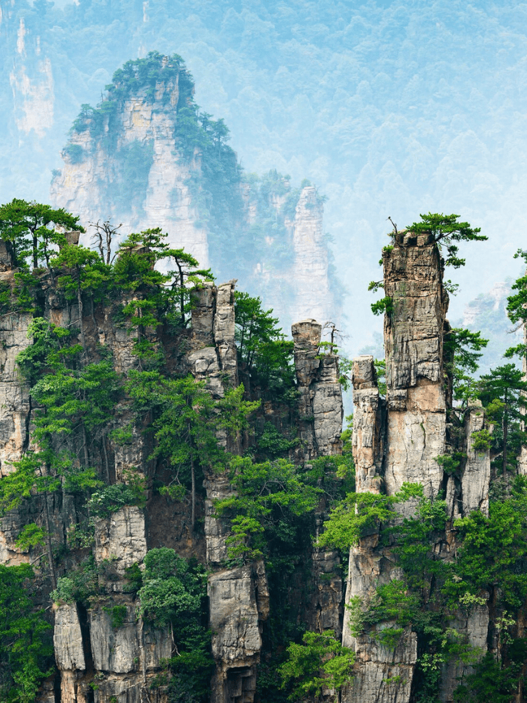 Vast mountain landscape with towering rock formations and lush green trees, scenic natural scenery at Zhangjiajie.