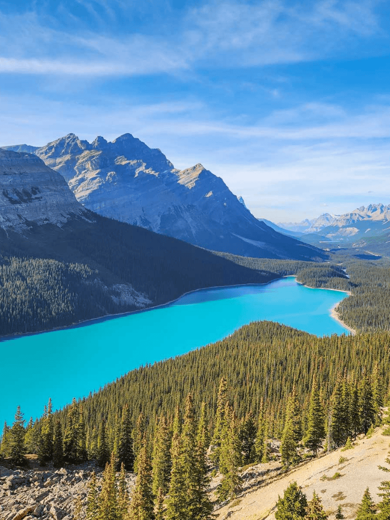 Pristine mountain lake surrounded by lush forest and towering peaks in a scenic wilderness area.